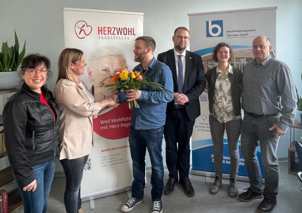 Mehrere Menschen haben sich zu einem Gruppenbild aufgestellt.