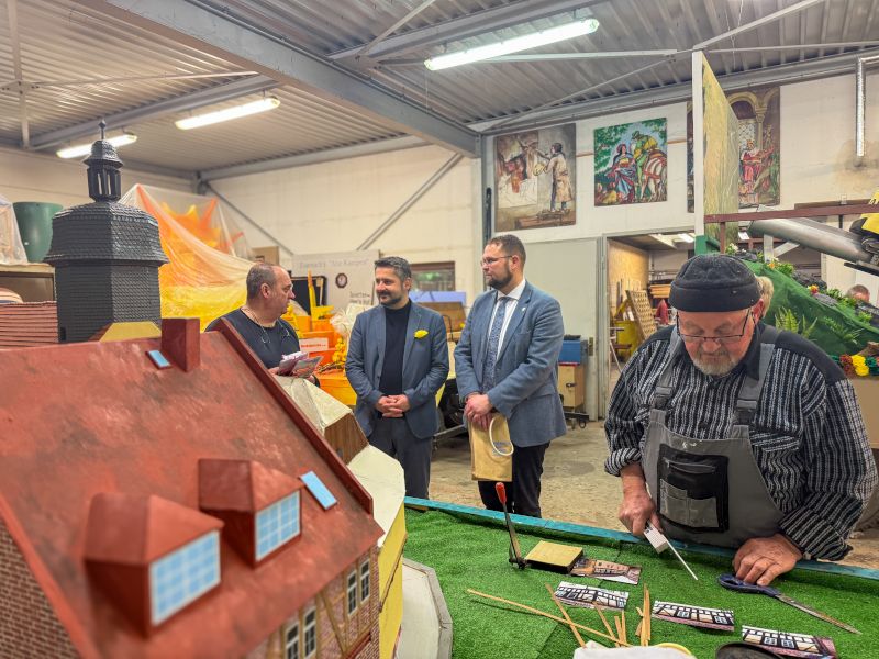 Mehrere Männer schauen sich dem Wagenbau zum Sommergewinn an.
