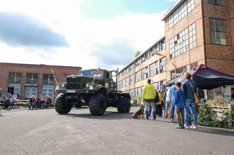 Vor der Fassade eines eindrücklichen Backsteinbaus steht ein Truck.