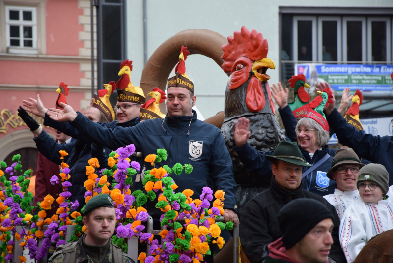 Mehrere Männer mit Kappen stehen auf einem Wagen.