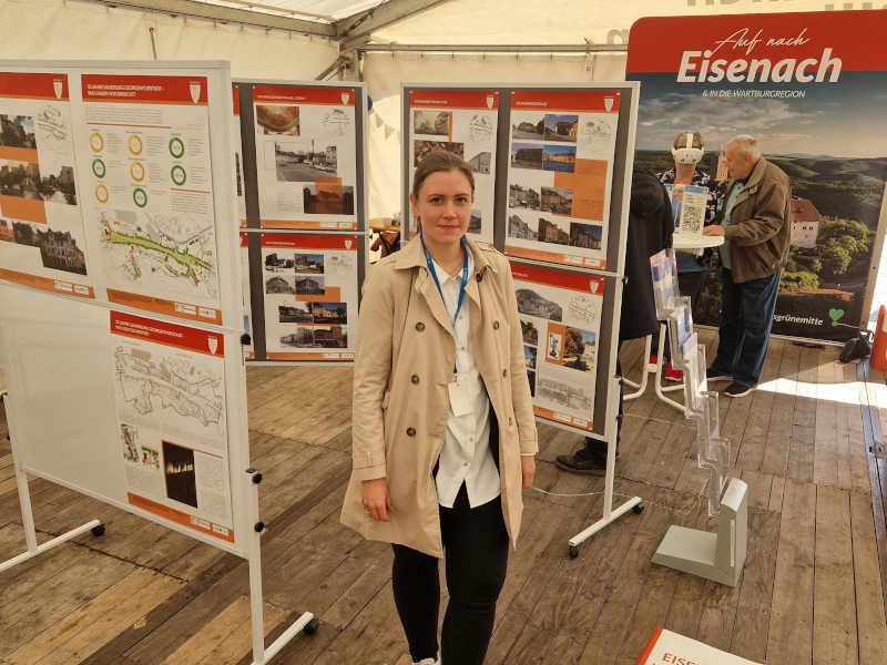 Eine Frau steht zwischen Ausstellungstafeln.
