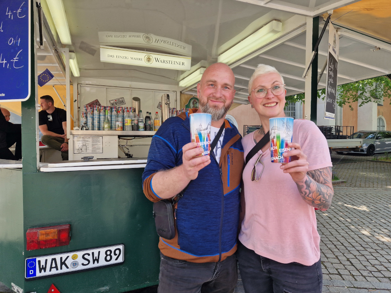 Ein Mann und eine Frau halten Becher.
