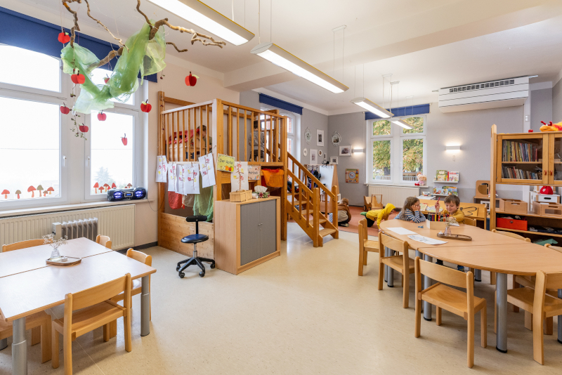 Spielzimmer eines Kindergartens mit Klettergerüst, Tischen und Stühlen und Dekoration