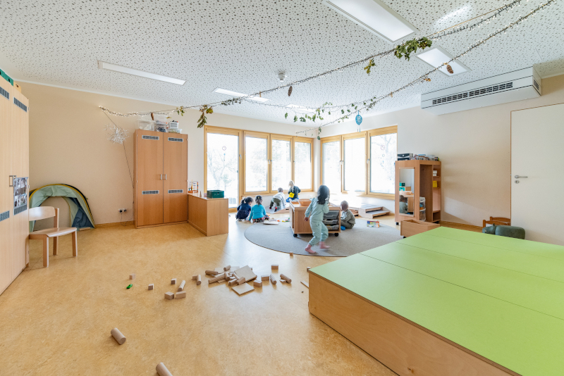 Ein heller Gruppenraum mit Holzmöbeln