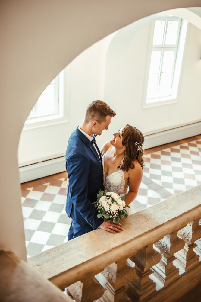 Ein Brautpaar steht in einem Treppenhaus.