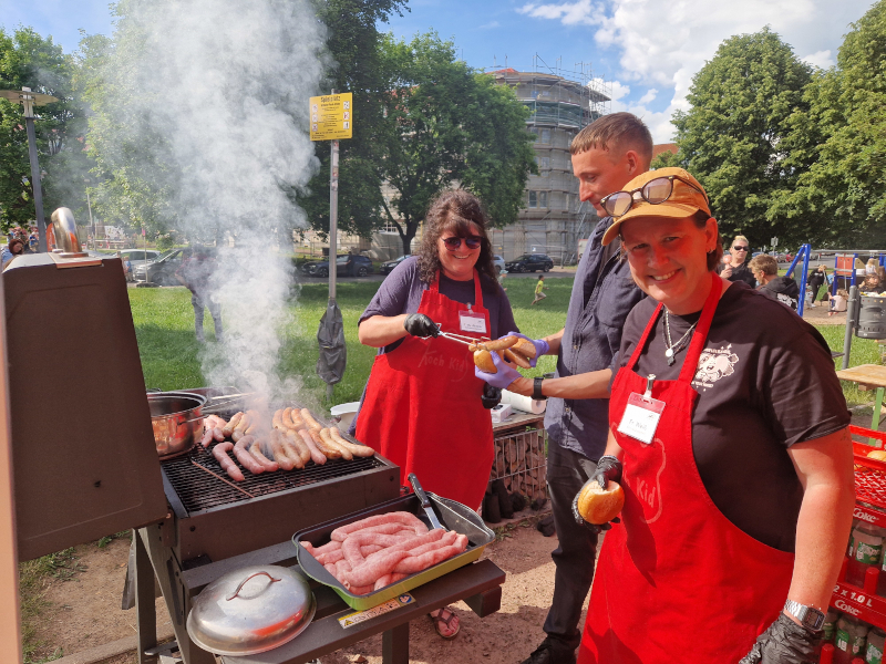 Fleißige Helfer grillen und verteilen Bratwürste.