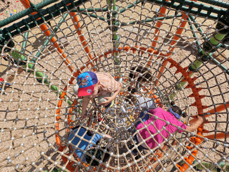 Kinder klettern im großen Spielturm mit Fallschutz.